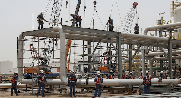 Oil and gas construction workers erecting a large industrial scaffolding system